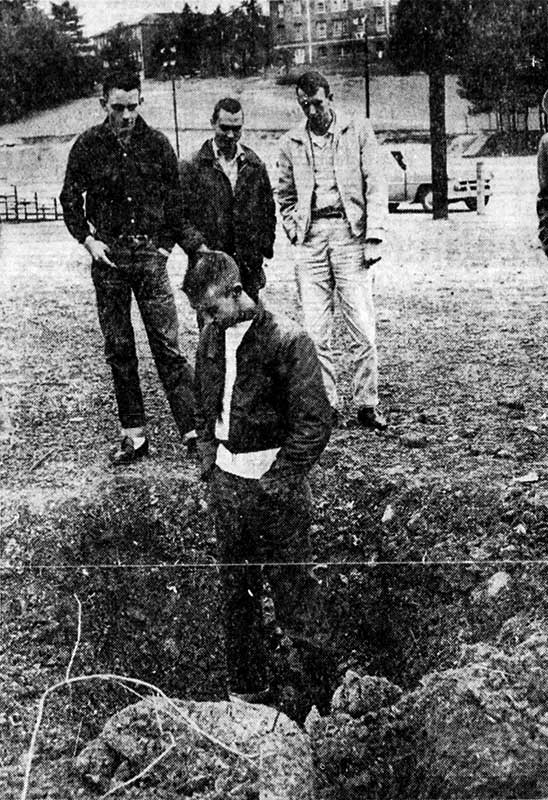 Four youths stand in a hole blown in the Spruce Pine baseball field on the evening of December 31,1959